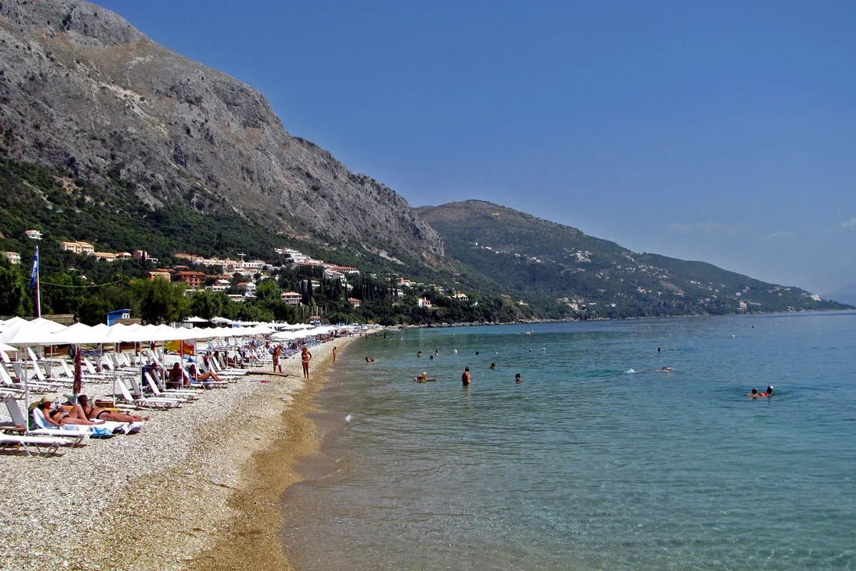 Barbati beach under Mount Pantokrator, the first swim stop on a Corfu sailing boat tour from Gouvia